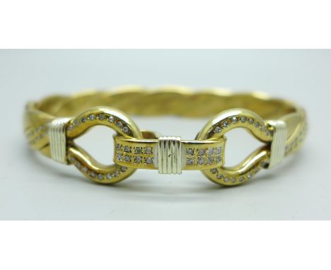 A 9ct gold 'Gucci' twist bangle with double loop design clasp and set with diamonds, bears TJ makers mark, 83g, inner dimensi