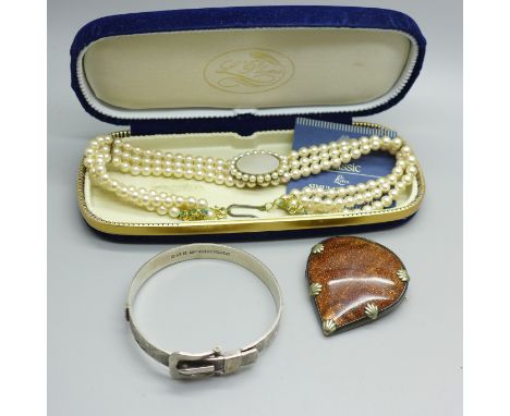 A silver buckle bangle, a goldstone pendant and a simulated pearl necklace 