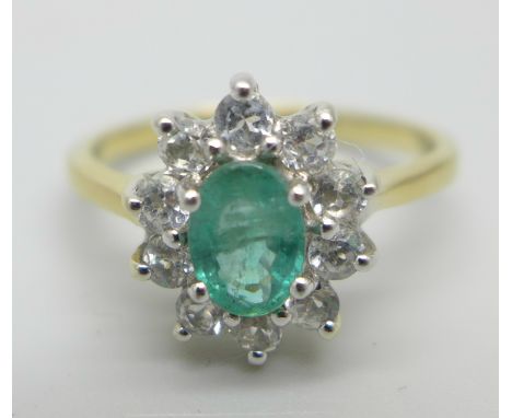 A silver gilt cluster ring set with a central emerald and white stone halo, S 