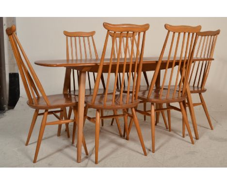 Ercol - A vintage 20th Century blonde beech and elm wood refectory plank dining table being raised on shaped supports. Togeth