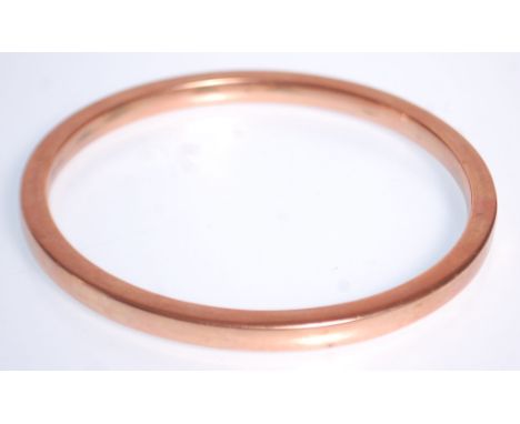 A large hallmarked 9ct gold slave bangle of plain form. Hallmarked for Birmingham date letter Z. Makers mark rubbed. Weighs 1