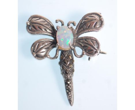A stamped 925 silver brooch in the form of a dragon fly set with an opal and marcasites. Measures 3cm. Weight 3.7g.&nbsp;