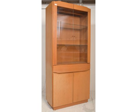 A 20th century Danish Skovby light oak modernist display cabinet. Raised on a plinth base with cupboard and single drawer und