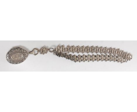 A vintage silver necklace having finley engraved panel links with a large locket pendant with similar decoration. Unmarked bu