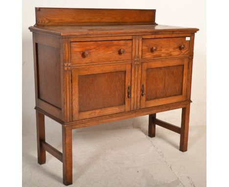 An early 20th Century Edwardian oak sideboard / credenza, gallery back with flared top over two drawers having panel doors be