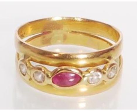 A stamped 750 18ct gold ring having a split band set with a marquise ruby cabochon flanked by four round cut diamonds. Weight