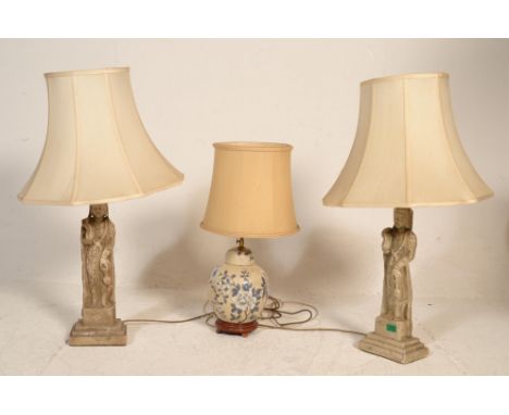 A pair of faux carved stone religious large table lamps, each with figural uprights complete with shades together with a Chin