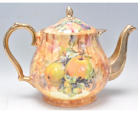 A large early to mid 20th Century teapot in the manor of Aynsley having transfer printed fruit decoration with gilt handle an