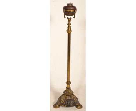 A 19th Century Victorian free standing oil lamp raised on a round base with three shell formed feet, having a central extendi