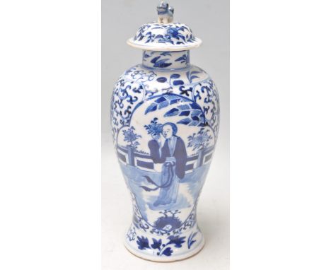 A 19th Century Chinese porcelain lidded baluster vase being painted with blue and white having a central panel depicting a fe