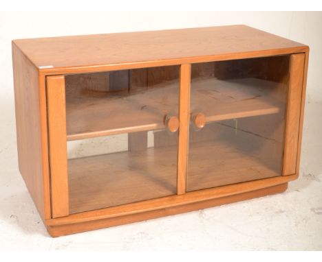 A good Ercol TV display unit stand of rectangular form having twin glazed doors with shaped wooden handles and shelf within. 