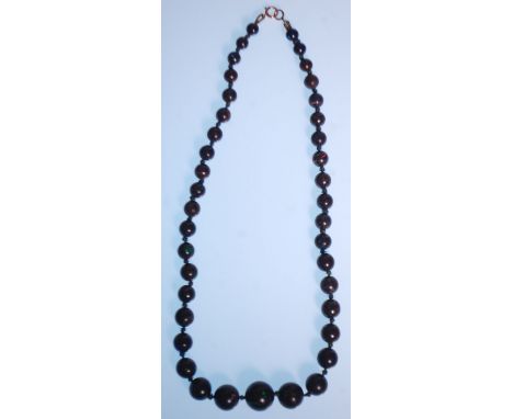 A 20th Century opal beaded necklace having forty round beads of graduation form, on a 9ct gold spring ring clasp. Measures 16