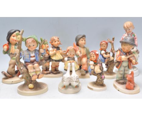 A collection of nine Goebel Hummel ceramic figurines to include apple tree boy, violinist, girl in a cherry blossom tree etc.
