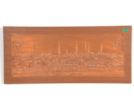 A retro 20th century teak wood and copper panel pressed into relief with scene of hamburg 1668 having town and river scene wi