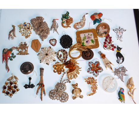 A collection of vintage brooches to include two scottish grouse claw brooches, a bird brooch with an enamelled beak, floral b