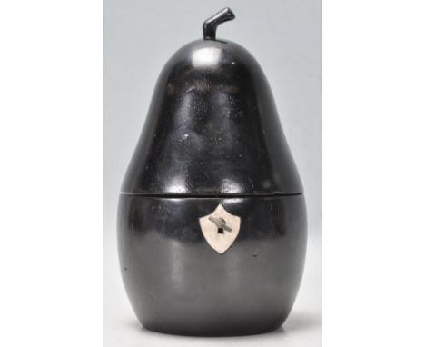 An antique style tea caddy in the form of a pear carved from ebonised wood having a shield scutcheon to the front with lock. 