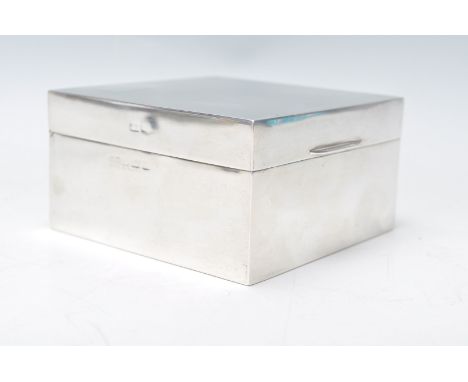 A silver hallmarked cigarette box of square form having an engine turned lid and unengraved rectangular panel to the corner, 