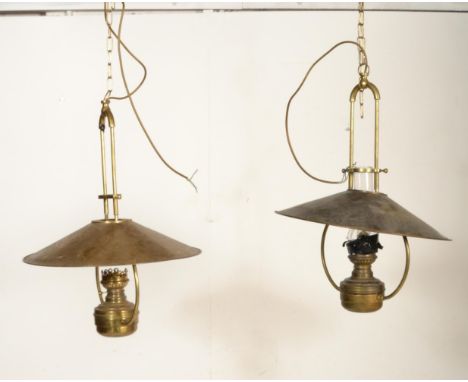 A pair of large and impressive brass ceiling lights of antique form having brass UFO saucer shades, large brass tubular mount