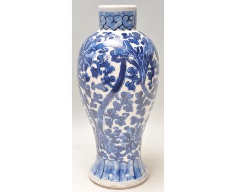 A 19th Century Chinese porcelain blue and white baluster vase being hand painted with scrolling floral decoration with four K