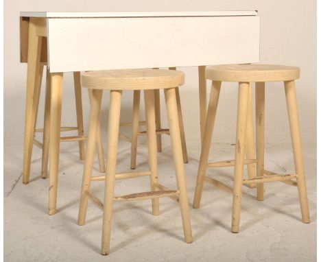 A retro mid century drop leaf formica kitchenette table and set of 4 kitchen diner stools having turned legs and stretcher wi