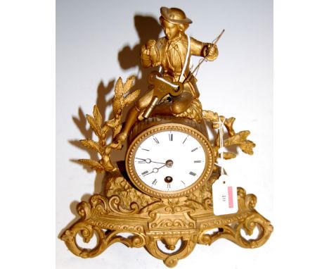 A late 19th century French gilt metal mantel clock, having enamelled dial with Roman numerals, surmounted by seated figure an