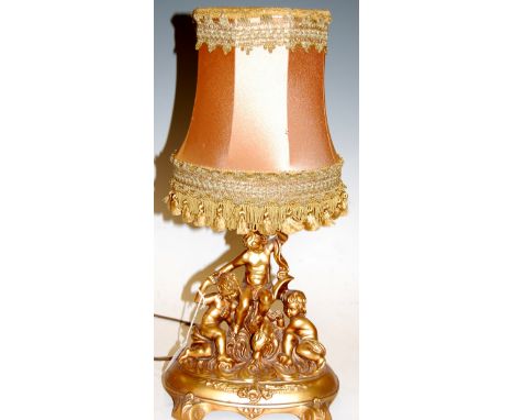 A late 20th century resin table lamp the whole surmounted by three cherubs, with silk shade, height 47cm