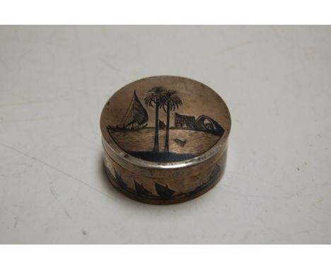 An early 20th century white metal snuff-box and cover, of cylindrical form, niello decorated with sailing ships and camels, d