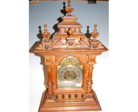 A large late 19th century continental walnut cased mantel clock having a brass dial with silvered chapter ring and Arabic num