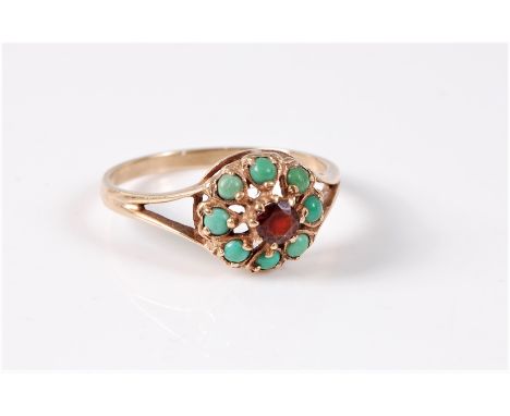 A 9ct garnet and turquoise cluster ring, the round garnet surrounded by small turquoise cabochons, with split shoulders and p