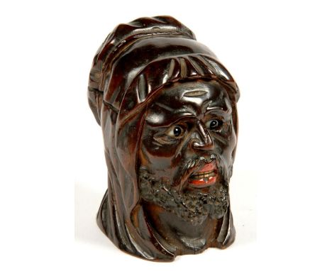 A CONTINENTAL RICHLY PATINATED WOOD NOVELTY INKWELL, CARVED IN THE FORM OF THE HEAD OF A BEARDED MAN WITH POLYCHROME DETAIL A