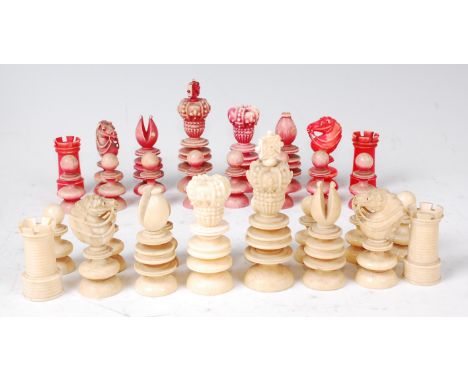 A Victorian carved ivory chess set, one side stained red, the other left natural, the kings each surmounted with a cross (cro