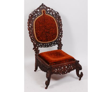 A late 19th century Burmese carved padouk chair, the padback within a carved and pierced surround of fruiting vines, over pad