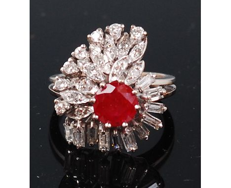 A modern white metal, ruby and diamond set cocktail ring, the centre round cut and claw set ruby weighing approx 0.5ct in a f