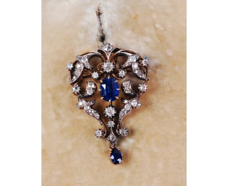 A circa 1900 yellow metal, sapphire and diamond set openwork pendant brooch, the centre oval cut sapphire weighing approx 0.7