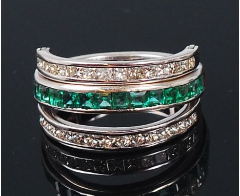 A contemporary 14ct white gold, ruby, emerald and diamond set triple eternity ring, the central band half set with baguette c