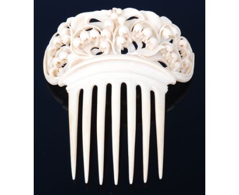 A late 19th century ivory comb, carved with scroll leaves and branches issuing bellflowers, w.12cm80