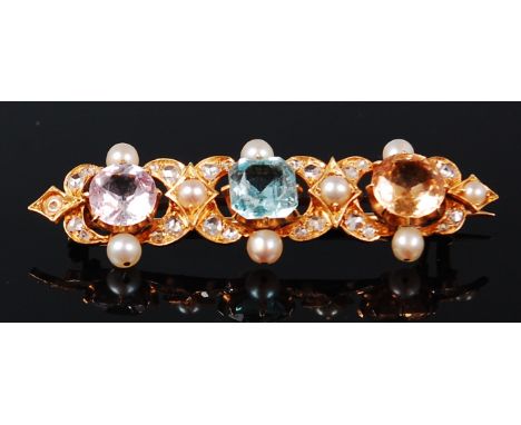 An 18ct gold multi-stone set bar brooch, centre set with an amethyst, blue topaz and citrine, in a surround of seed pearls (o