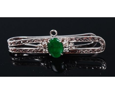 A white metal (tests as 18ct gold), jade and diamond set tie-clip, the cabochon jade flanked to either side by three claw set