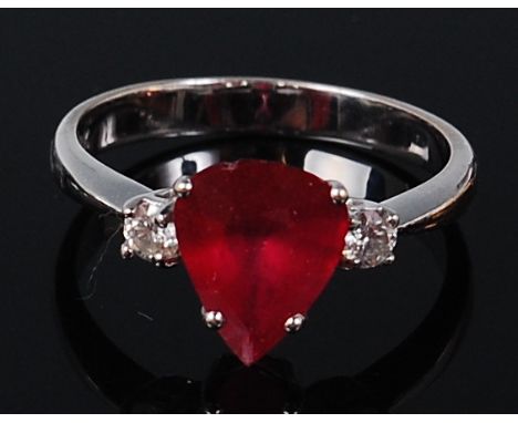 An 18ct white gold, ruby and diamond ring, arranged as a four claw set pear cut ruby (small chip to edge) weighing approx 1.5
