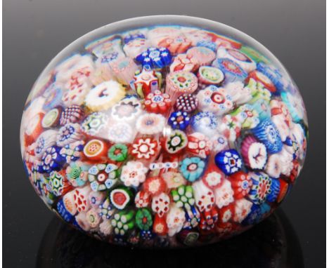 A Baccarat millefiori glass paperweight, the closely packed multicoloured canes including animal silhouettes and stemmed flow