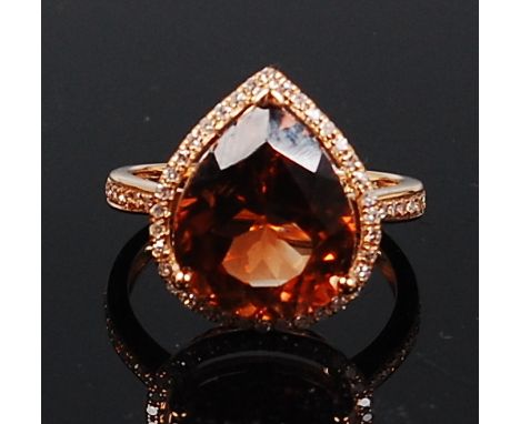 A contemporary 14ct gold and champagne topaz set ring, the three claw set pear cut topaz weighing approx 7.4ct, in a surround