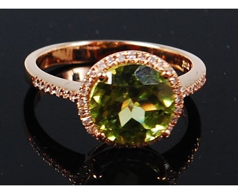 A 14ct gold, peridot and diamond ring, the round cut peridot weighing approx 3.2ct, in a surround of small brilliants, the sh