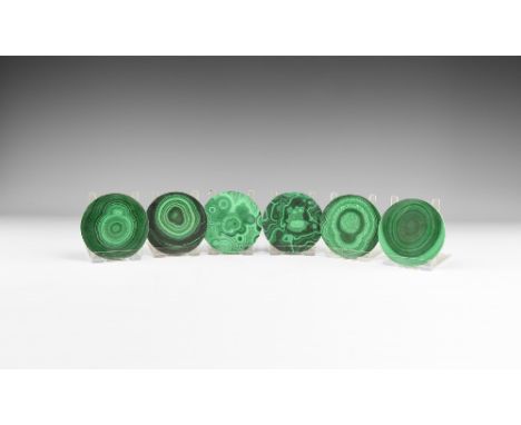 A group of six cut and polished circular malachite coasters with pale and dark green banding. See Bonewitz, Dr. Ronald Louis,