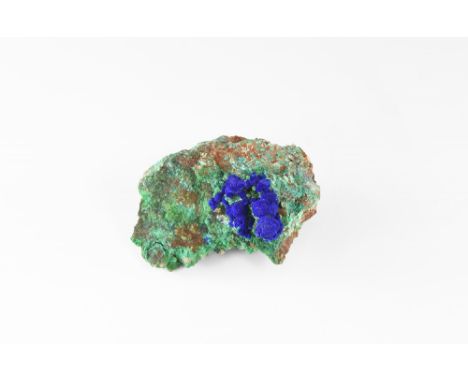 A specimen of malachite on matrix, with a cluster of spherical azurite aggregates to one end, in white card tray with label r