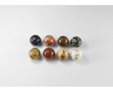 A group of polished mineral spheres including: three brecciated jasper, unakite, snowflake obsidian, tiger iron, howlite, sod