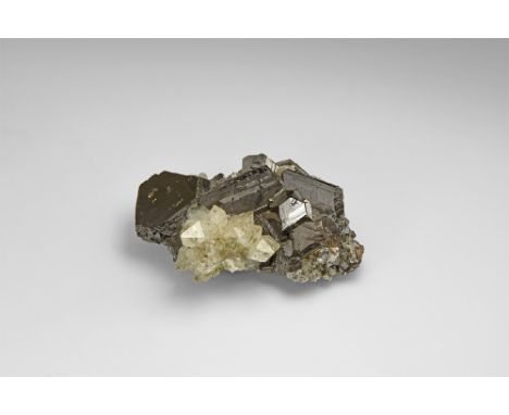 A cluster of large, well-formed sphalerite crystals with lustrous faces and a cluster of radiating quartz crystals, from Peru