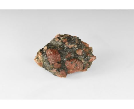 A large piece of granitic rock with varying sized cohenite (formerly called austenite) crystals; with old hand written adhesi