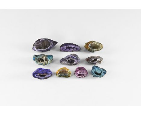 A group of ten cut and polished agate geodes of varying colours and with clusters of crystals in the central cavities; colour