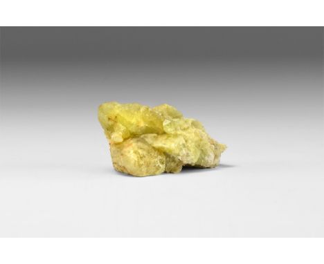 A large piece of brazilianite crystal in a pale green colour with numerous crystal spikes, in white card tray with handwritte