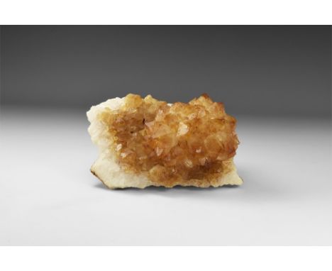 A sheet of yellow-brown citrine crystals from Brazil, on a white quartz base, some crystal tips a darker red-brown forming a 
